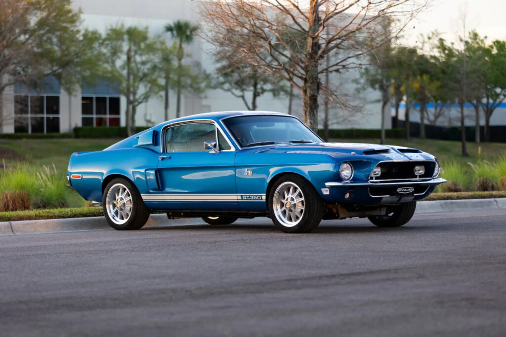 1968 Shelby GT350 in blue with white stripes, parked roadside.