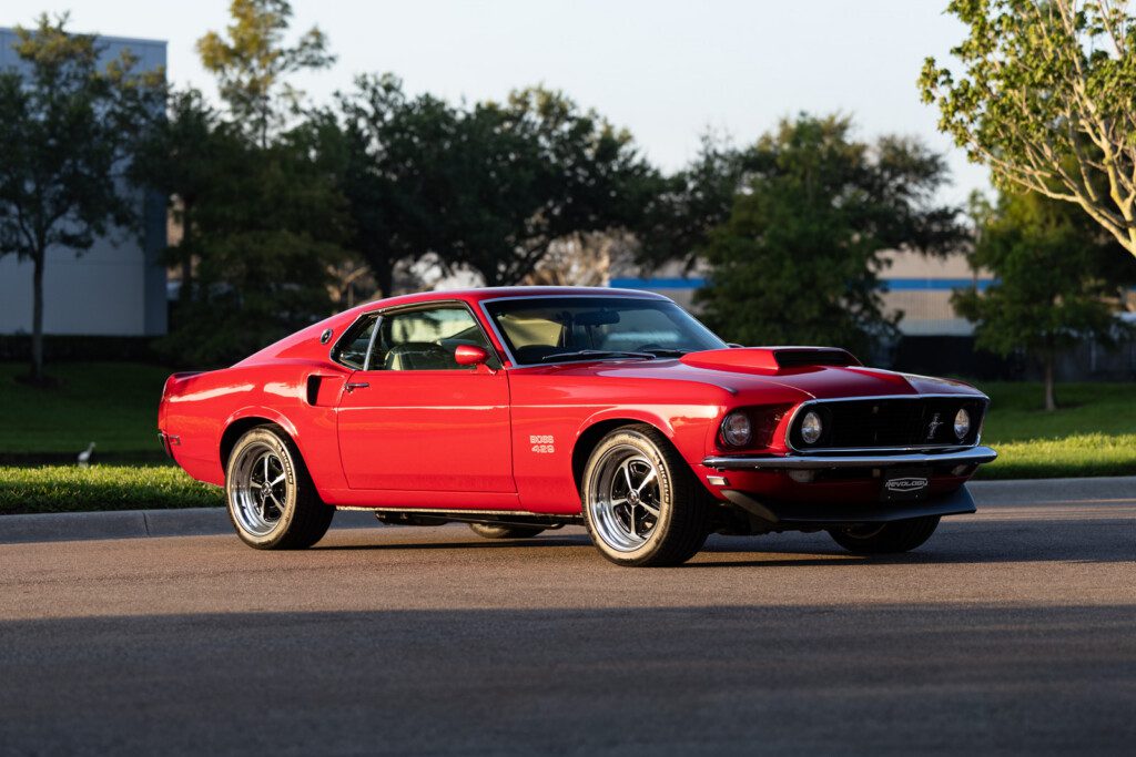 Red 1969 Mustang Boss 429 Fastback parked on a road in a front three-quarter view.